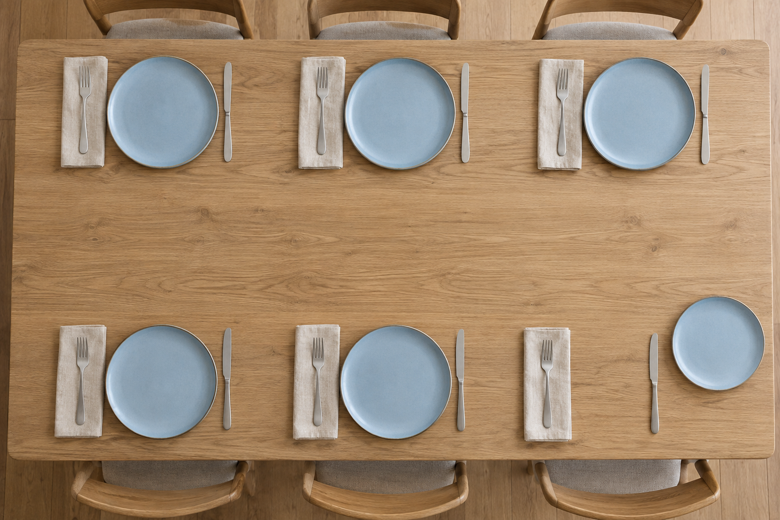 Overhead view of six simple table settings with one replacement ceramic dinner plate beside an empty setting