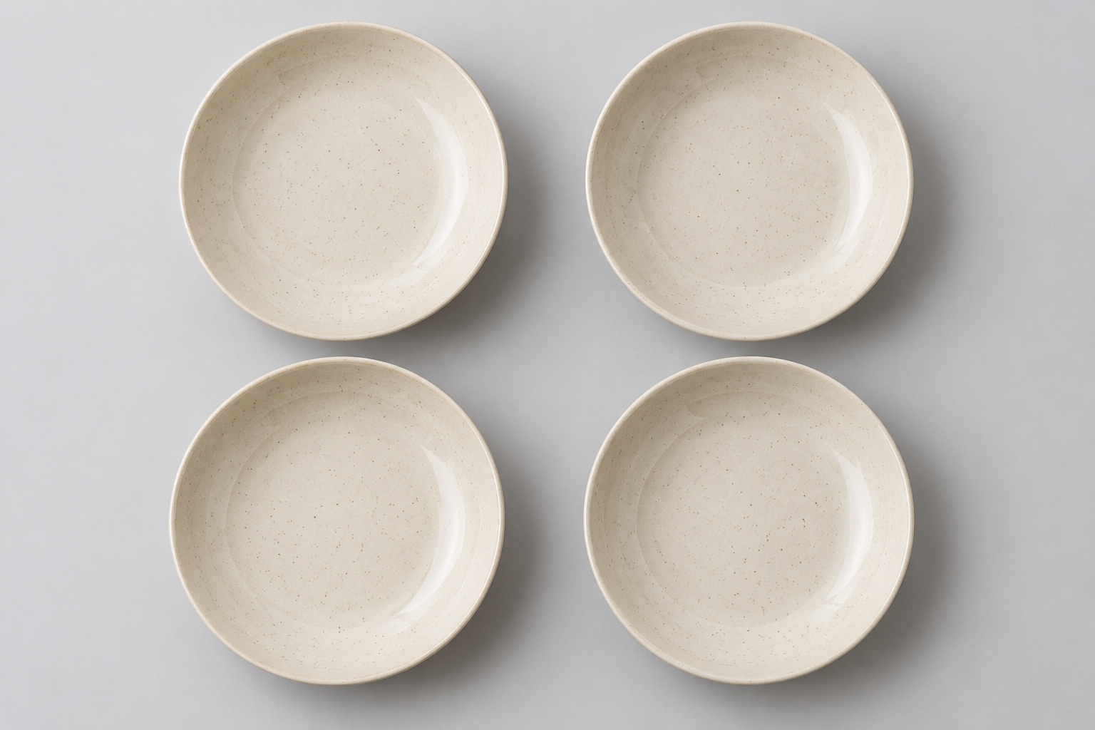 Four separate ivory ceramic pasta bowls arranged in a two-by-two layout so buyers can count the set contents